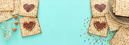 Pesah celebration concept (jewish Passover holiday) with chocolate heart and colorful candies over...