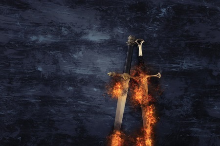 Low key banner of silver sword in the flames of fire. Fantasy medieval periodの写真素材