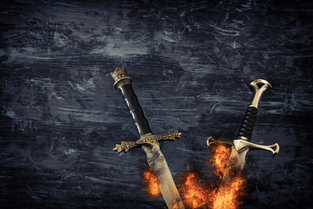 Low key banner of silver sword in the flames of fire. Fantasy medieval periodの写真素材