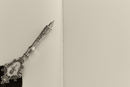 Old feather pen and empty sheet of paper. Back drop background. View from above. Black and white.の写真素材