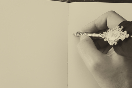 Old feather pen and empty sheet of paper. Back drop background. View from above. Black and white.の写真素材