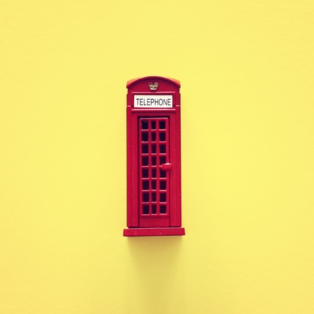 London traditional red phone booth over yellow background.の写真素材