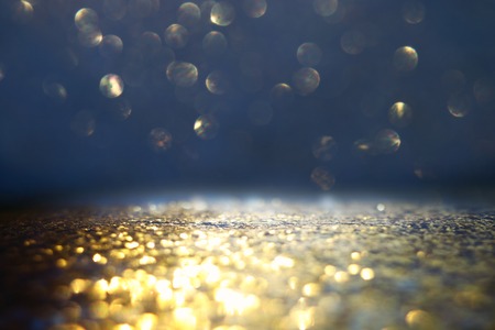 glitter vintage lights background. black and gold. de-focused