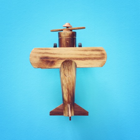 top view photo of wooden vintage toy airplane over blue background