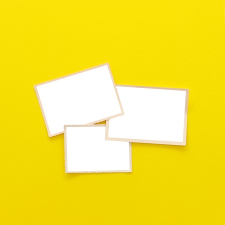 Top view of blank photo frames over yellow background. Top view flat layの写真素材