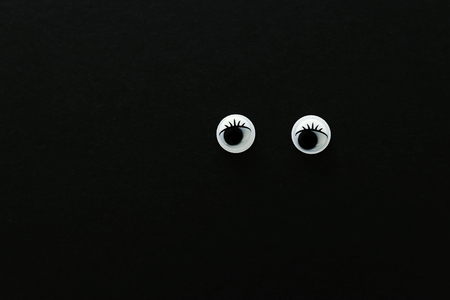 Pair googly eyes over black backgroundの写真素材