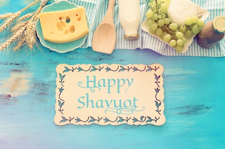 Top view photo of dairy products over blue wooden background. Symbols of Jewish holiday - Shavuot