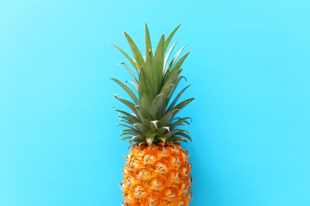 Ripe pineapple over blue background. Beach and tropical theme. Top viewの写真素材