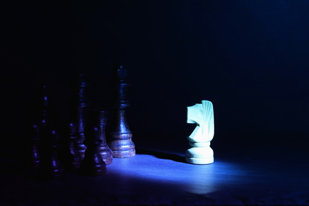 Wooden chess figures under dark and dramatic lightingの写真素材