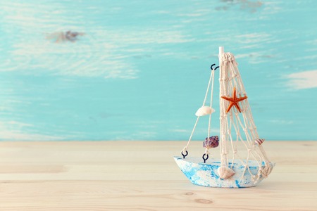 Vintage boat over wooden table or shelf and pastel blue backgroundの写真素材