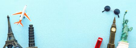 Top view banner photo of traveling concept with accessories and world symbols over blue background