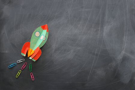 Education. Back to school concept. Rocket cut from paper and painted over blackboard background. Top view, flat layの写真素材