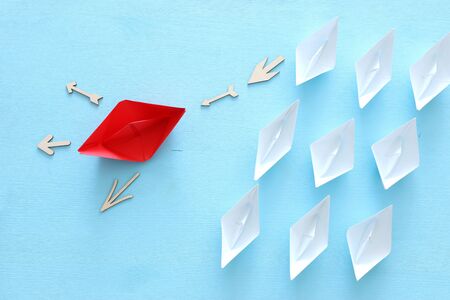 business. Leadership concept image with paper boats on blue wooden background. One leader guiding others.の写真素材