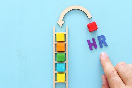 Business image of wooden ladder with colorful cubes over blue table, human resources and management conceptの写真素材