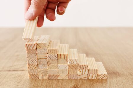 Business image of arranging wood blocks stacking as step stairs. Success and development concept