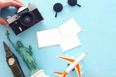 Top view photo of traveling concept with accessories, blank photo frames for mockup and world symbols over blue backgroundの写真素材