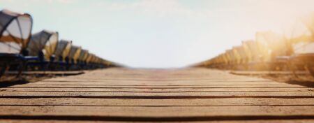 Holidays image of wooden deck at tropical beach chairs under umbrellas. Summer travel and vacation concept. Bannerの写真素材