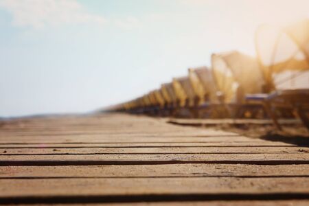 Holidays image of wooden deck at tropical beach chairs under umbrellas. Summer travel and vacation conceptの写真素材