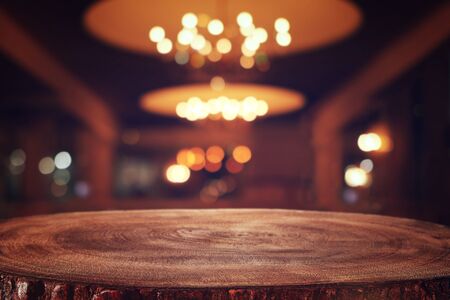 background Image of wooden table in front of abstract blurred restaurant lights