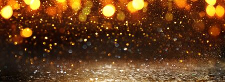 background of abstract glitter lights. gold and black. de-focused. banner