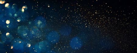 background of abstract glitter lights. blue, gold and black. de focused. banner