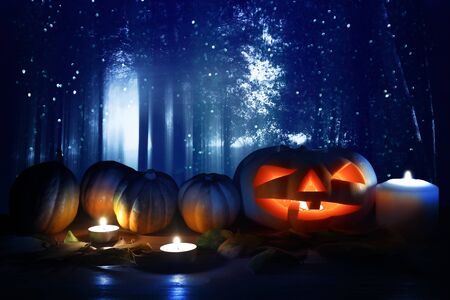 holidays concept of Halloween . Pumpkins over wooden table at night scary, haunted and misty forestの写真素材