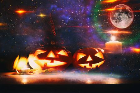 holidays image of halloween. Pumpkins over wooden table at night scary, haunted and misty forestの写真素材