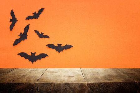 holidays concept of Halloween. Empty rustic table in front of bats background. Ready for product...