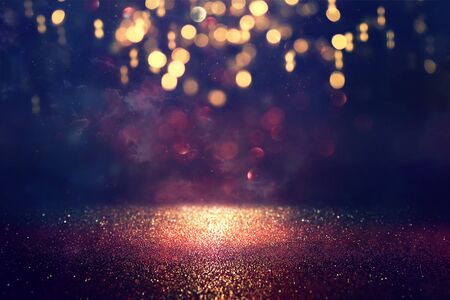 background of abstract glitter lights. gold and black. de focused