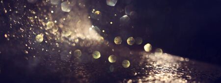 background of abstract glitter lights. gold and black. de focused. banner