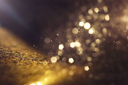 background of abstract glitter lights. gold and black. de focused