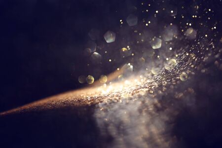 background of abstract glitter lights. gold and black. de focused
