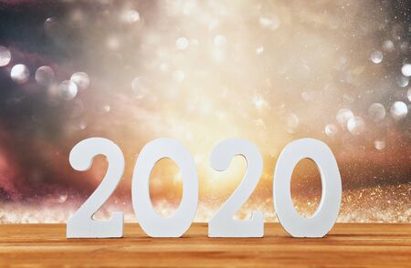 Background of 2020 happy new year concept, wooden numbers over table and glitter backgroundの写真素材