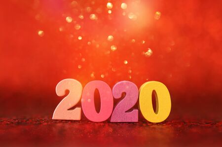 Holiday image of New Year 2020 concept. Wooden number and sparkling background
