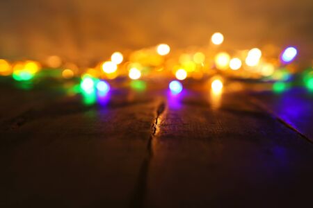 background image of abstract blurred gold and colorful garland lights. defocused