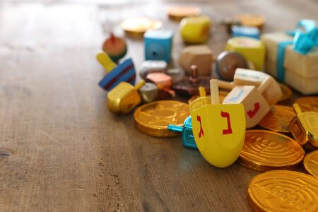 religion concept of of jewish holiday Hanukkah with wooden dreidels (spinning top) and chocolate coins over wooden tableの写真素材