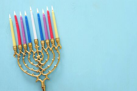 Religion image of jewish holiday Hanukkah background with menorah (traditional candelabra) and candles over pastel blue background. top view, flat layの写真素材
