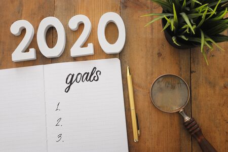 Business concept of top view 2020 goals list with notebook over wooden deskの写真素材