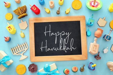 religion image of jewish holiday Hanukkah background with menorah (traditional candelabra), spinning top over wooden blue background. top view, flat layの写真素材