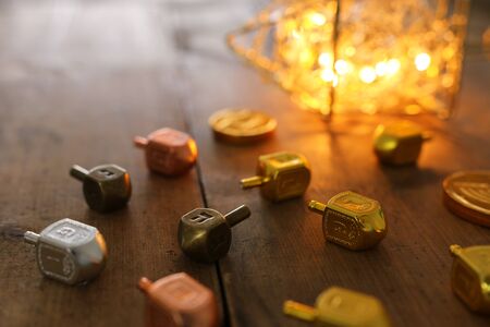 religion concept of of jewish holiday Hanukkah with dreidels (spinning top) wooden table and wooden backgroundの写真素材