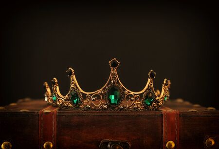 low key image of beautiful queen/king crown over wooden table. vintage filtered. fantasy medieval...