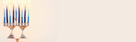 Religion image of jewish holiday Hanukkah background with david star menorah (traditional candelabra) and candlesの写真素材