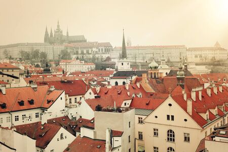 Prague tile roofs of old houses, castle and cathedral. view from above. vintage and mostalgic style...