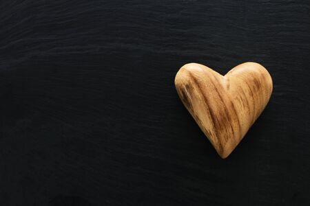 Valentines day concept. wooden heart over black background. Flat lay composition