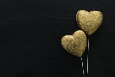 Valentines day concept. gold glitter hearts over black background. Flat lay composition