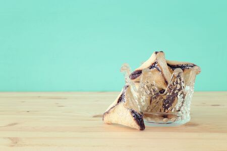 Purim celebration concept (jewish carnival holiday). Hamantaschen cookies over wooden table
