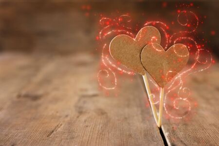 Valentines day concept. two hearts over wooden background and glitter lights