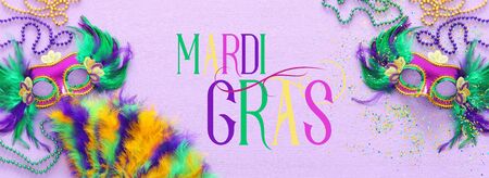 Holidays image of mardi gras masquarade, venetian mask and fan over purple background. view from aboveの写真素材
