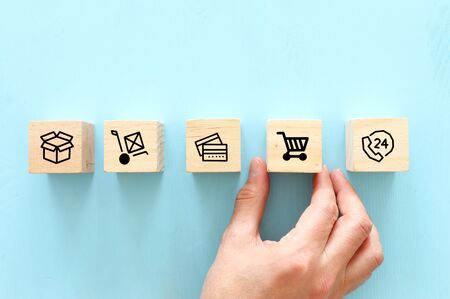 shopping and bussines concept. hand picking wooden cube