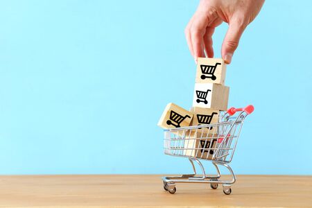 shopping and bussines concept. hand picking wooden cubeの写真素材